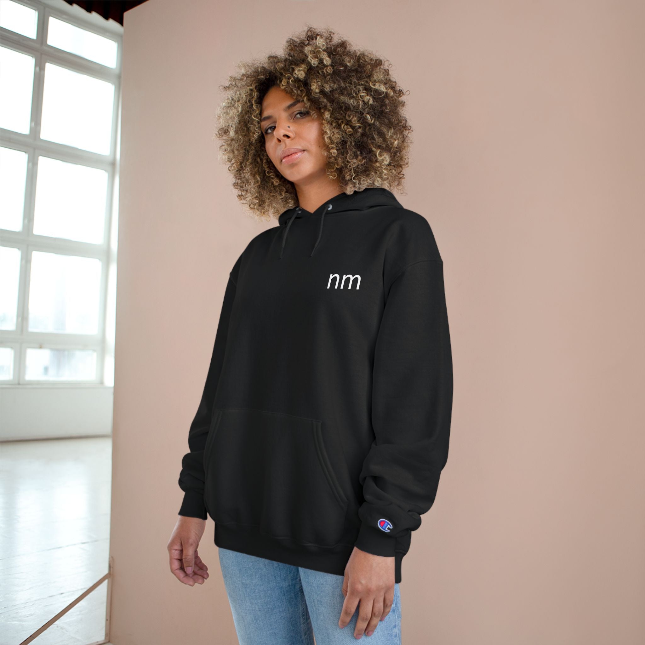 Person wearing a black hoodie with 'nm'